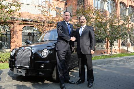 英国首相卡梅伦与金年会控股集团董事长李书福在伦敦经典黑色出租车前亲切握手。 